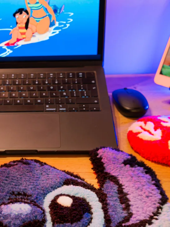 Tapete de tufting de Stitch bajo un portátil, con mouse pad rojo de flores