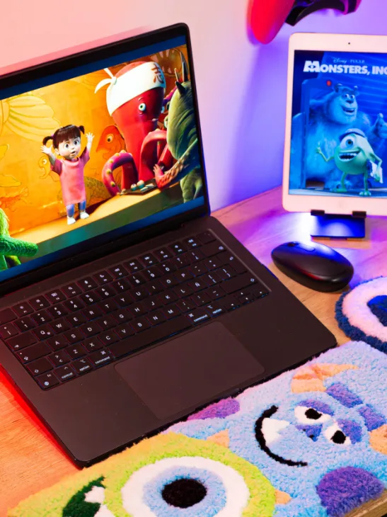 Kit de escritorio con Mike Wazowski y Sulley en lana, frente a un portátil y una tableta